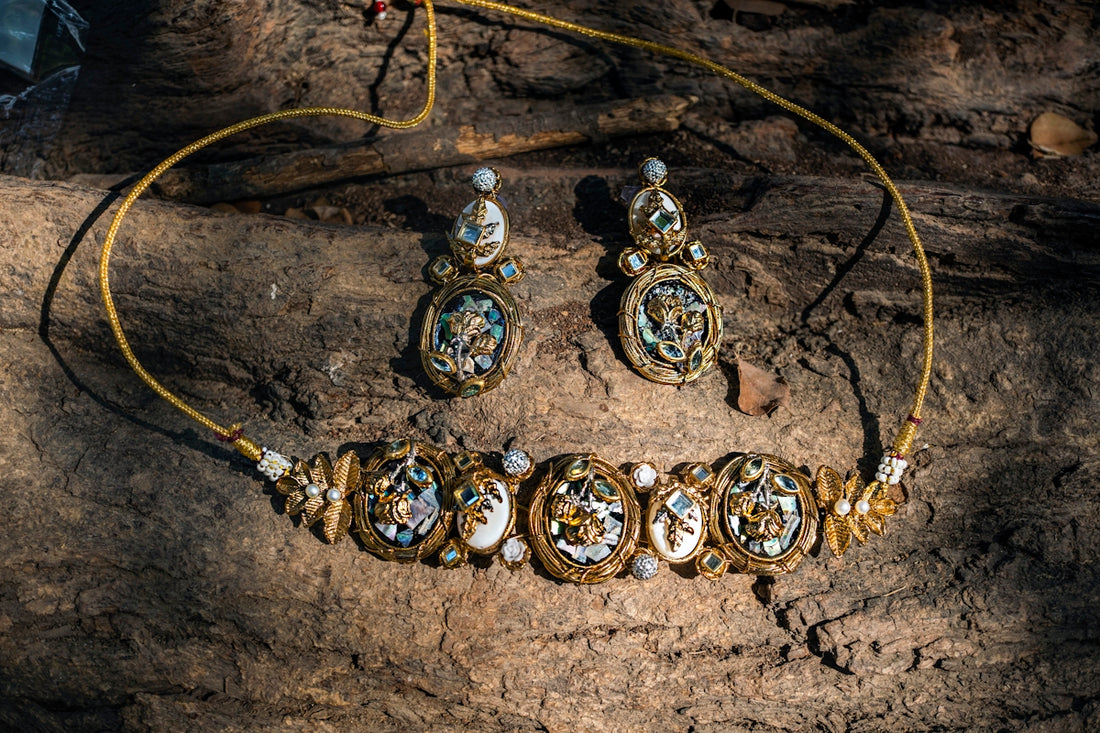 A necklace and earrings sitting on top of a rock