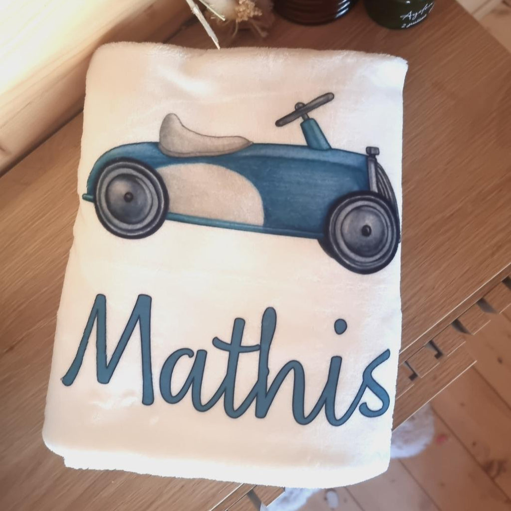 Couverture bébé personnalisée avec motif voiture vintage bleue et prénom inscrit.
